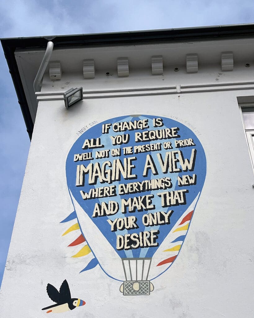 Inspirational quote mural on building wall with hot air balloon