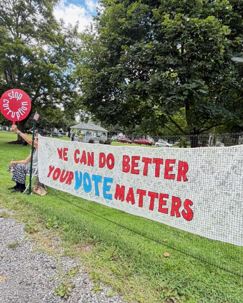 Protest banner reading Your Vote Matters in a park